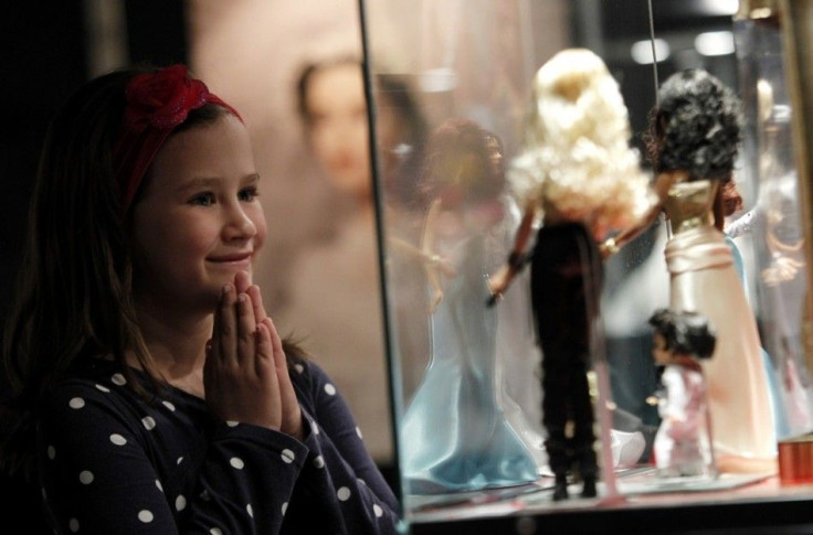 A girl looks at Barbie dolls during a Barbie exhibition in Zagreb May 15, 2012.