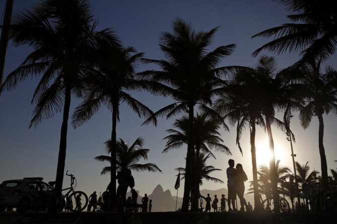 A couple embrace as they wait to view the sunset at Arpoador Beach in Rio de Janeiro August 24, 2014.