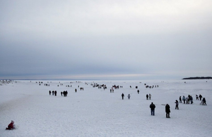 Sightseers make their way onto the frozen shores of Lake Erie to view ice caves in Crystal Beach, Ontario February 17, 2014. A cool autumn and early winter combined with polar vortexes helped lake ice build up weeks earlier than normal, said George Leshke