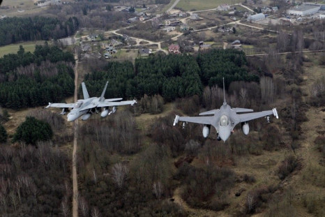 Portuguese Air Force fighter F-16 (R) and Canadian Air Force fighter CF-18 Hornet patrol over Baltics air space, from the Zokniai air base near Siauliai November 20, 2014. NATO pilots practised scrambling their jets on Wednesday, in preparation for potent