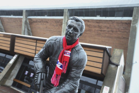 A view of a Jean Beliveau statue draped with a Montreal Canadiens scarf, is seen front of an arena named after Beliveau in Longueuil