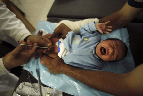 A Palestinian baby is circumcised at Patient Care Association in Gaza May 20, 2010. Circumcision is a common surgery for Muslims in accordance to the teachings of Prophet Mohammed. They believe that it purifies the body from dirtiness, and immunizes it fr