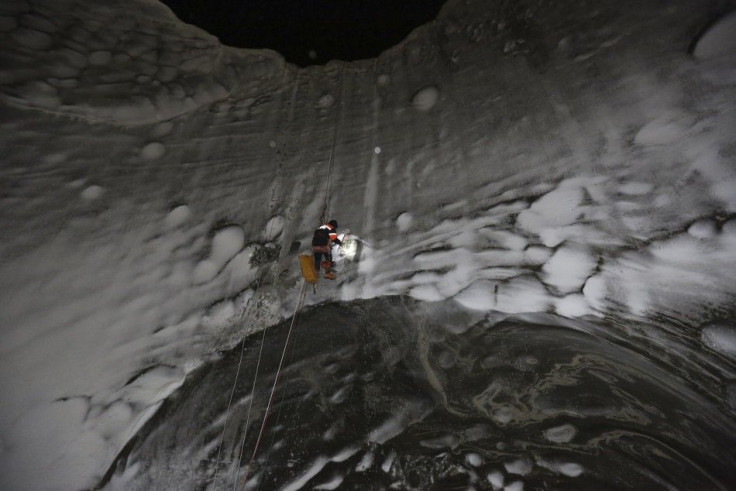 A member of an expedition group explores a newly formed crater on the Yamal Peninsula, northern Siberia November 8, 2014. A group of scientists and discoverers in November went on an expedition initiated by the Russian Centre of Arctic Exploration to rese