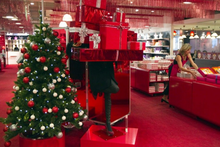An employee in the toy section of the Galeries Lafayette department store arranges a display near a Christmas tree in preparation for holiday season gift shopping in Paris November 17, 2011.