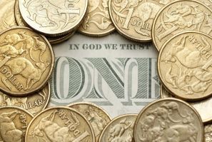 Australian one dollar coins surround a U.S. one dollar note in this photo illustration taken in Sydney July 27, 2011. Australian consumer prices rose by more than expected last quarter while underlying inflation proved alarmingly high, reviving pressure f