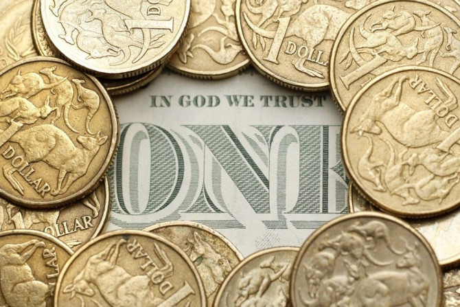 Australian one dollar coins surround a U.S. one dollar note in this photo illustration taken in Sydney July 27, 2011. Australian consumer prices rose by more than expected last quarter while underlying inflation proved alarmingly high, reviving pressure f