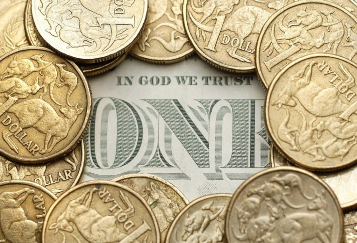 Australian one dollar coins surround a U.S. one dollar note in this photo illustration taken in Sydney July 27, 2011. Australian consumer prices rose by more than expected last quarter while underlying inflation proved alarmingly high, reviving pressure f