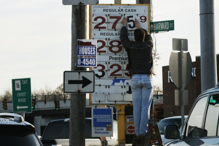 A man changes the price for a gallon of gasoline at a gas station