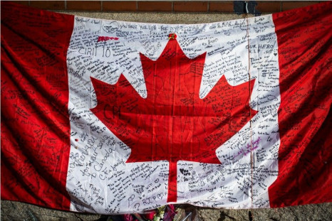 Messages are seen on a Canadian flag in a makeshift memorial in honour of Cpl. Nathan Cirillo