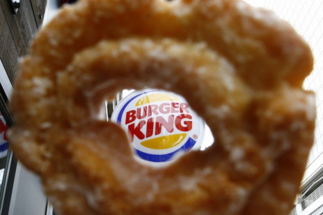 The Burger King logo is seen through a Tim Horton's doughnut hole in a photo illustration outside a restaurant in Toronto August 29, 2014. Burger King's proposed $11.5 billion acquisition of Canada's Tim Hortons may offer big tax benefits t