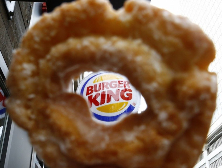 The Burger King logo is seen through a Tim Horton's doughnut hole in a photo illustration outside a restaurant in Toronto August 29, 2014. Burger King's proposed $11.5 billion acquisition of Canada's Tim Hortons may offer big tax benefits t