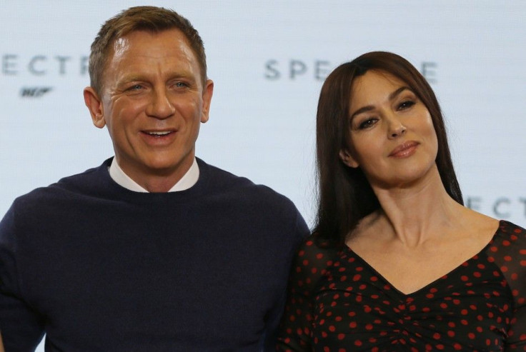 Actors Daniel Craig (L) and Monica Bellucci pose on stage during an event to mark the start of production for the new James Bond film &quot;Spectre&quot;