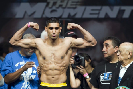 Amir Khan of Britain poses on the scale during an official weigh-in at the MGM Grand Garden Arena in Las Vegas, Nevada, May 2, 2014. Khan will face Luis Collazo of the U.S. for a welterweight fight at the arena on May 3.