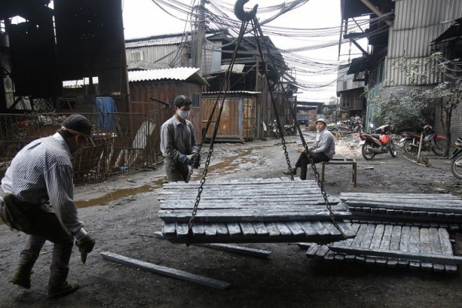 Men load pieces of steel at a steel factory in Chau Khe village, outside Hanoi December 4, 2014. The World Bank said on Wednesday it has revised its forecast for Vietnam's economic growth this year to 5.6 percent from 5.4 percent previously, after the gov