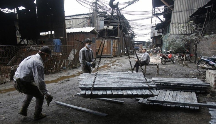 Men load pieces of steel at a steel factory in Chau Khe village, outside Hanoi December 4, 2014. The World Bank said on Wednesday it has revised its forecast for Vietnam's economic growth this year to 5.6 percent from 5.4 percent previously, after the gov