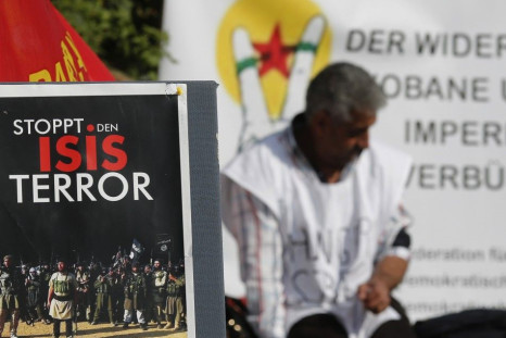 A Kurdish protester sits behind a sign reading &quot; STOP ISIS terror&quot; in front of the United Nations headquarters in Vienna October 9, 2014. A group of Kurdish people living in Austria are on hunger strike since Monday in solidarity for Syrian Kurd