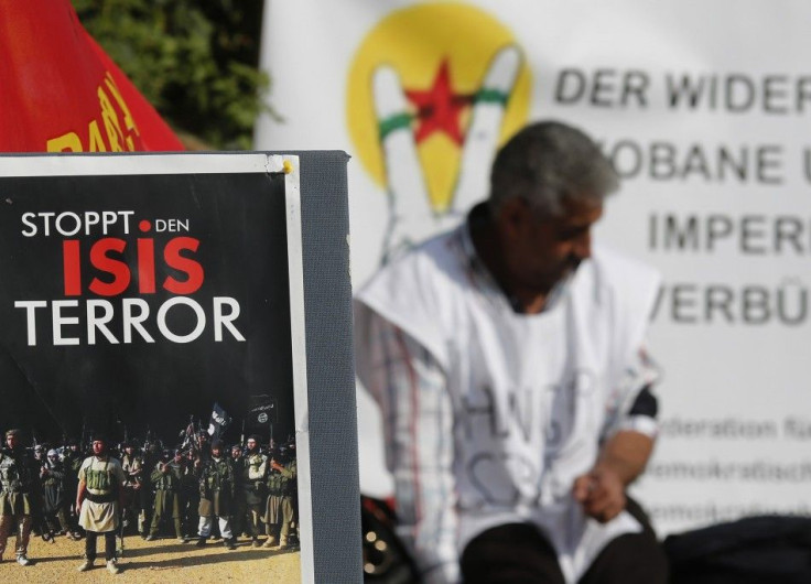 A Kurdish protester sits behind a sign reading &quot; STOP ISIS terror&quot; in front of the United Nations headquarters in Vienna October 9, 2014. A group of Kurdish people living in Austria are on hunger strike since Monday in solidarity for Syrian Kurd