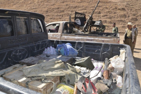 Kurdish peshmerga fighters examine vehicles with weapons and ammunition left behind by fleeing Islamic State militants during clashes in the al-Zerga area near Tikrit city in Salahuddin province October 8, 2014. Kurdish peshmerga forces backed by Shi&#039