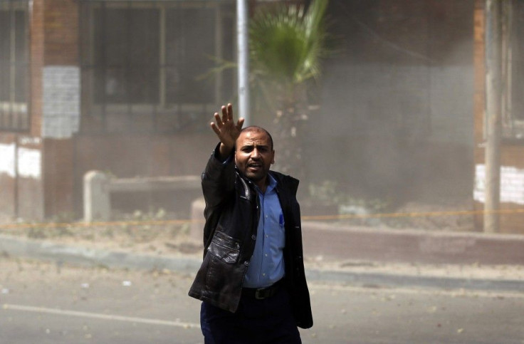 A man reacts after an explosion, which was followed by two further blasts, in front of Cairo University