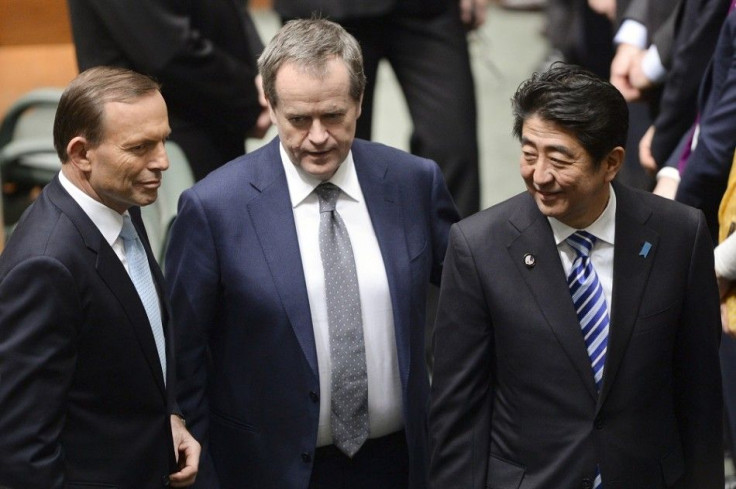 Japan's Prime Minister Shinzo Abe (R) is pictured on the floor of Australia's House of Representatives with Australian Prime Minister Tony Abbott (L) and Australian Opposition Leader Bill Shorten following Abe's address to both houses of parliament in Can