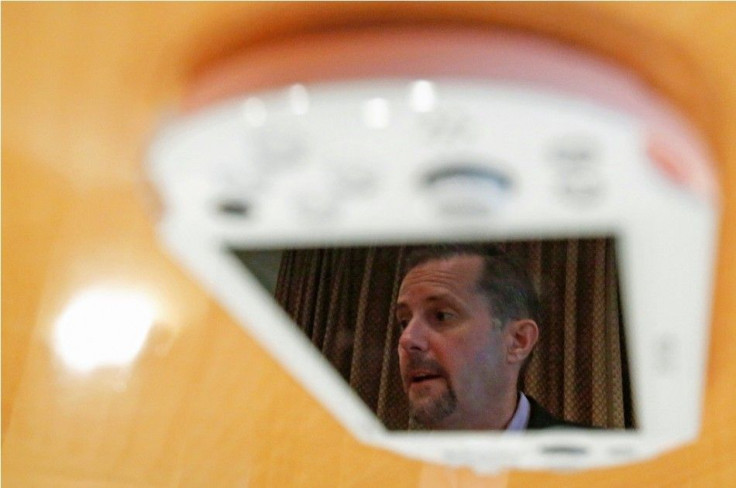 Sony Computer Entertainment's President and Group CEO Andrew House is reflected in the display screen of a PlayStation Vita handheld game console