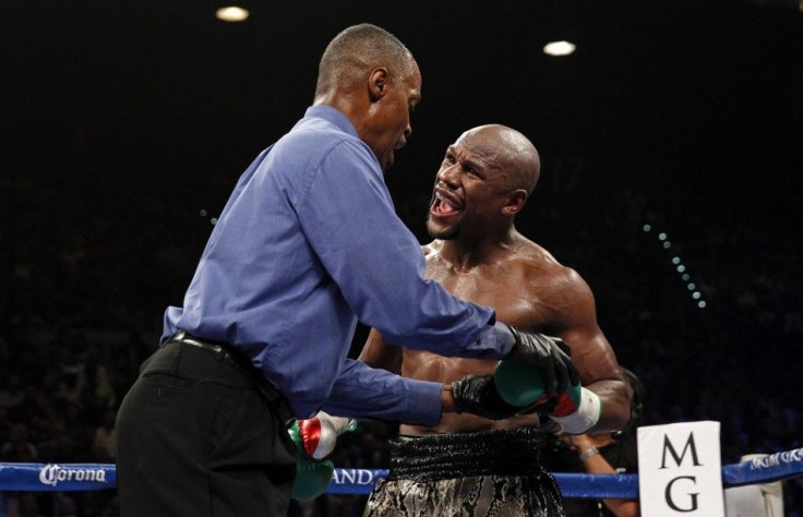 WBC/WBA welterweight champion Floyd Mayweather Jr. (R) of the U.S. complains that Marcos Maidana of Argentina bit him as referee Kenny Bayless examines his glove during their title fight at the MGM Grand Garden Arena in Las Vegas, Nevada September 13, 201