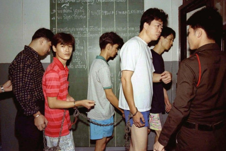 Policemen take five suspected drug traffickers to jail in a police station in Bangkok