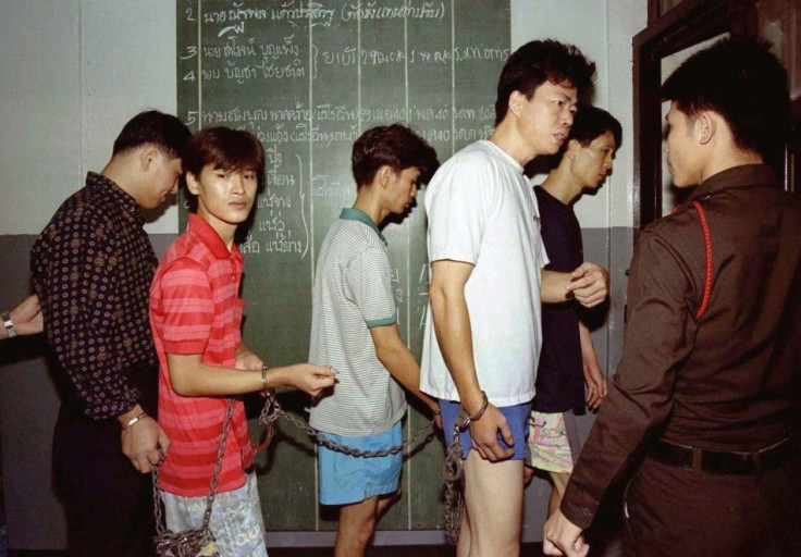 Policemen take five suspected drug traffickers to jail in a police station in Bangkok