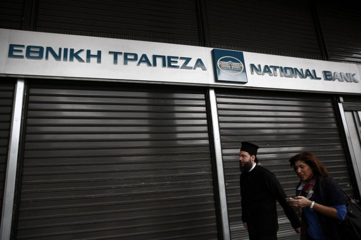People make their way in front of a closed National Bank of Greece branch in Athens October 26, 2014. Roughly one in five of the euro zone's top lenders failed landmark health checks at the end of last year but most have since repaired their finances, the