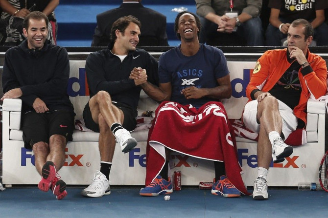 (L-R) Pete Sampras, Roger Federer, Gael Monfils and Cedric Pioline of the Micromax Indian Aces share a moment during their match against the Singapore Slammers at the International Premier Tennis League (IPTL) in New Delhi, December 7, 2014. REUTERS/Adnan