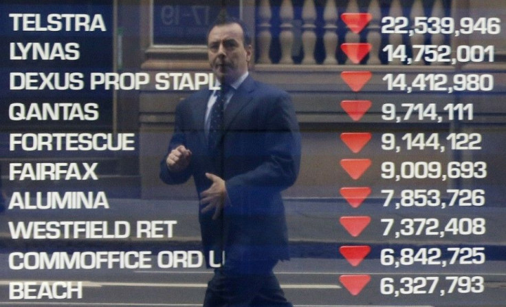 A man is reflected on a window of the Australian Securities Exchange building with a board showing the ten most heavily traded stocks for the day in central Sydney June 13, 2013. Australian shares earlier fell 1 percent to a fresh 5-1/2-month low as persi