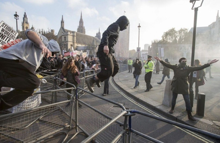 Demonstrators break through barricades in Parliament Square in front of the Houses of Parliament, as they participate in a protest against student loans and in favour of free education, in central London November 19, 2014.