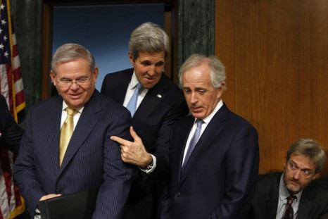 U.S. Secretary of State John Kerry (C) gestures between Senate Foreign Relations Committee Chairman Robert Menendez (D-NJ) (L) and Sen. Bob Corker (R-TN) before a hearing on &quot;Authorization for the Use of Military Force Against ISIL&quot; on Capitol H