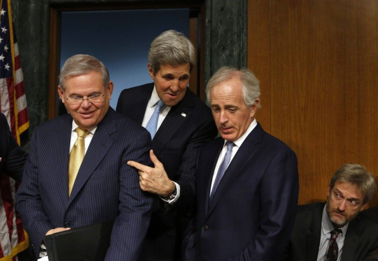 U.S. Secretary of State John Kerry (C) gestures between Senate Foreign Relations Committee Chairman Robert Menendez (D-NJ) (L) and Sen. Bob Corker (R-TN) before a hearing on &quot;Authorization for the Use of Military Force Against ISIL&quot; on Capitol H