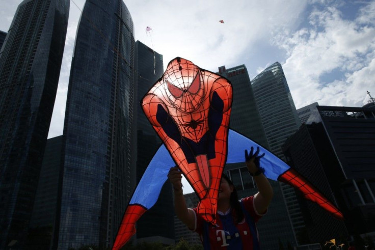 A woman flies a kite depicting comic book superhero Spider-Man kite