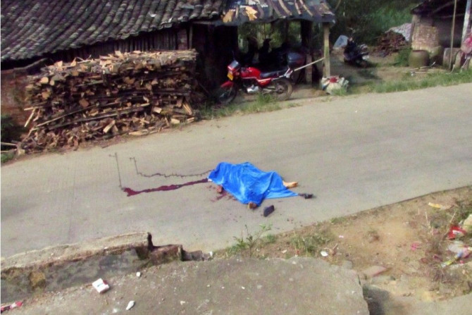 The body of a child is pictured on a road leading to a primary school in Lingshan county