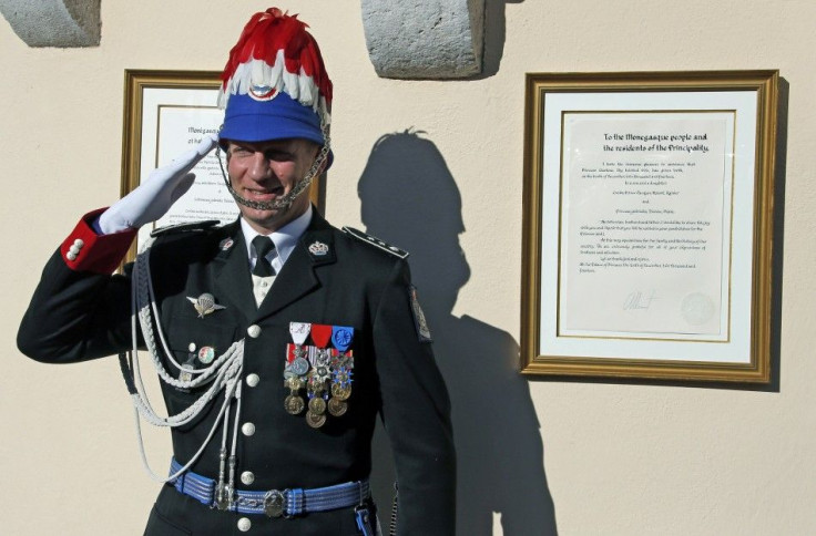 A carabinieri salutes as he stands next to the official declaration of Prince Albert II announcing the birth of twins of the Prince and Princess Charlene, at Monaco Palace December 11, 2014. Princess Charlene of Monaco gave birth on Wednesday to a boy and