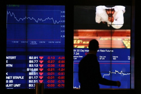 A man looks at screens displaying market information as he walks past the Australian Stock Exchange in central Sydney July 4, 2013. Australian shares rebounded 1 percent on Thursday, as Wall Street rose modestly higher overnight and a rise in metals price