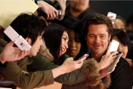 Cast member Brad Pitt takes pictures with fans as he promotes the movie &quot;Fury&quot; in Tokyo