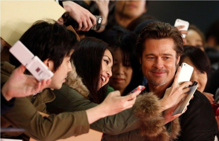 Cast member Brad Pitt takes pictures with fans as he promotes the movie &quot;Fury&quot; in Tokyo