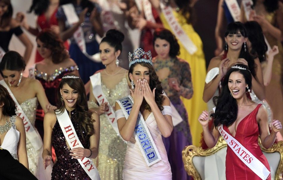 Rolene Strauss of South Africa C is crowned Miss World 2014 by Miss World 2013, Megan Young of the Philippines C rear, as Elizabeth Safrit of the U.S R and Edina Kulczar of Hungary L who placed third and second respectively