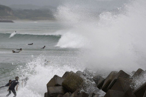 Waves crash as Typhoon Vongfong approaches Japan's main islands while surfers try to ride a wave at Eguchihama Beach in Hioki, Kagoshima prefecture, in this photo taken by Kyodo October 12, 2014. Typhoon Vongfong battered the southern Japanese island of O