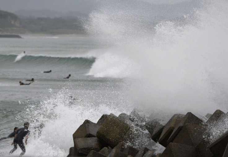 Waves crash as Typhoon Vongfong approaches Japan's main islands while surfers try to ride a wave at Eguchihama Beach in Hioki, Kagoshima prefecture, in this photo taken by Kyodo October 12, 2014. Typhoon Vongfong battered the southern Japanese island of O