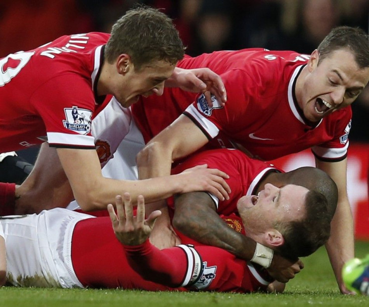 Manchester United&#039;s Wayne Rooney (on ground) celebrates with Michael Carrick (L), Jonny Evans (R) and Ashley Young (partially obscured), after scoring the opening goal during their English Premier League soccer match against Liverpool at Old Trafford