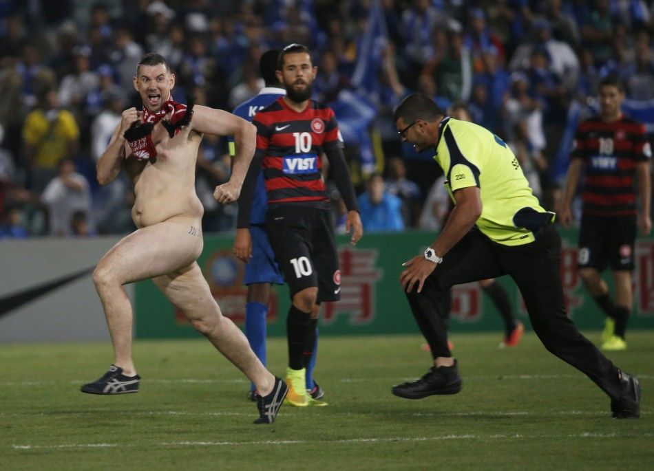 A streaker runs across the pitch as a security guard prepares to tackle him during the Asian Champions League final first-leg soccer match between Australias Western Sydney Wanderers and Saudi Arabias Al Hilal at Parramatta Stadium in Sydney October 25,