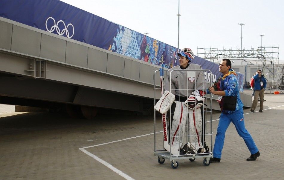 A volunteer pushes Switzerlands goaltender Sophie Anthamatten in a trolley as she leaves the Shayba Arena following a practice session ahead of the 2014 Sochi Winter Olympics, February 6, 2014. 