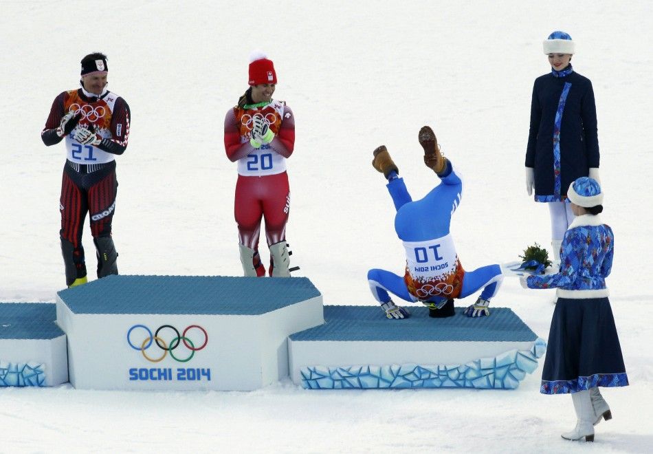Third-placed Italys Christof Innerhofer 2nd R does a somersault on the podium as winner Switzerlands Sandro Viletta 2nd L and second-placed Croatias Ivica Kostelic L laugh after the mens alpine skiing super combined event at the 2014 Sochi Winte
