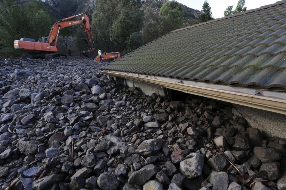 Rocks reach the roof of a home after a mudslide overtook at least 8 homes during heavy rains in Camarillo Springs, California, December 12, 2014. A majorstorm that pummeled northern California and the Pacific Northwest with heavy rain and high winds and k