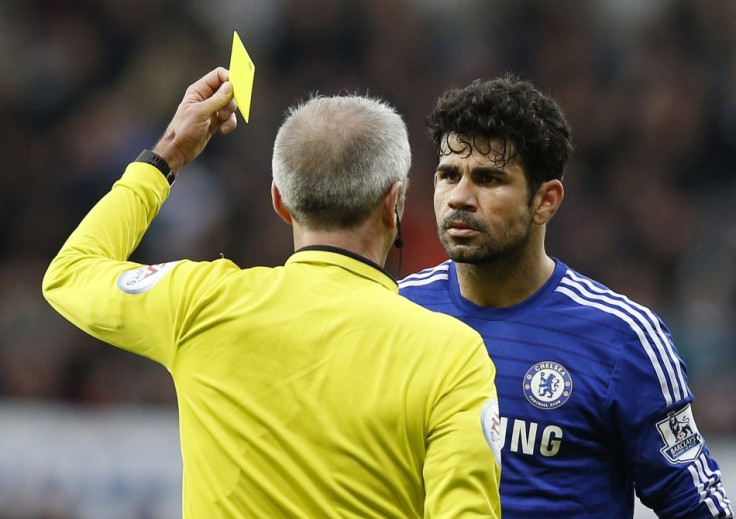 Chelsea's Diego Costa (R) is shown a yellow card by the referee Martin Atkinson during their English Premier League soccer match against Newcastle United at St James' Park in Newcastle, northern England December 6, 2014.
