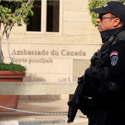 An armed police officer is deployed in front of the Canadian embassy in Cairo